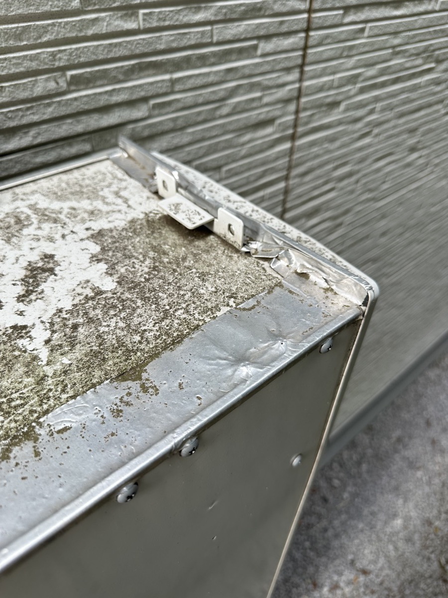 業者がアルミホイルで囲ってくれた給湯器天板の角の応急処置
