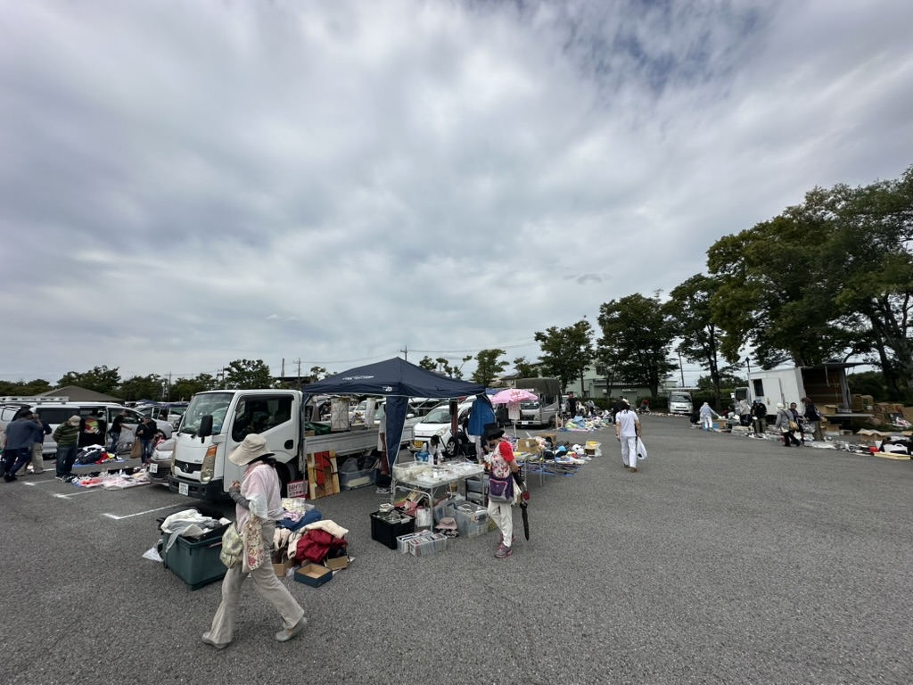 フリーマーケット会場で衣類や雑貨が地面に並ぶ業者出店の様子